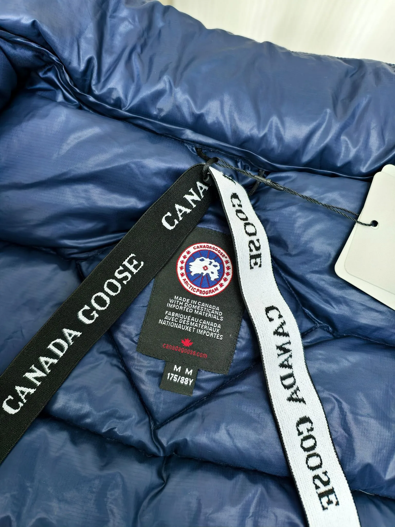 P880 2228M model (high version) Canada goose Crofton down jacket, this is a down jacket suitable for late autumn and early winter: on cold and rainy mornings, it can be used as a layer of warmth inside the rainproof jacket, and can be worn alone in the late autumn and early winter with a little bit of coolness. Filled with white duck down. The Crofton Jacket is a versatile, lightweight and versatile piece that even packs itself in for easy transport. The inner layer has removable elastic straps, making the jacket easy to carry on the shoulder and hands-free. 2 zippered hand pockets with fleece fabric on the knuckle side for softness and warmth. Color: black with black label, black with red label, ocean blue, superoxide blue, silver birch red label, silver birch black label Size: XS-2XL